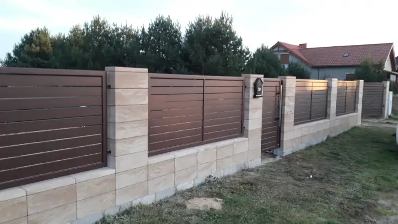 Ogrodzenie w kolorze drewnopodobnym na słupkach z bloczków