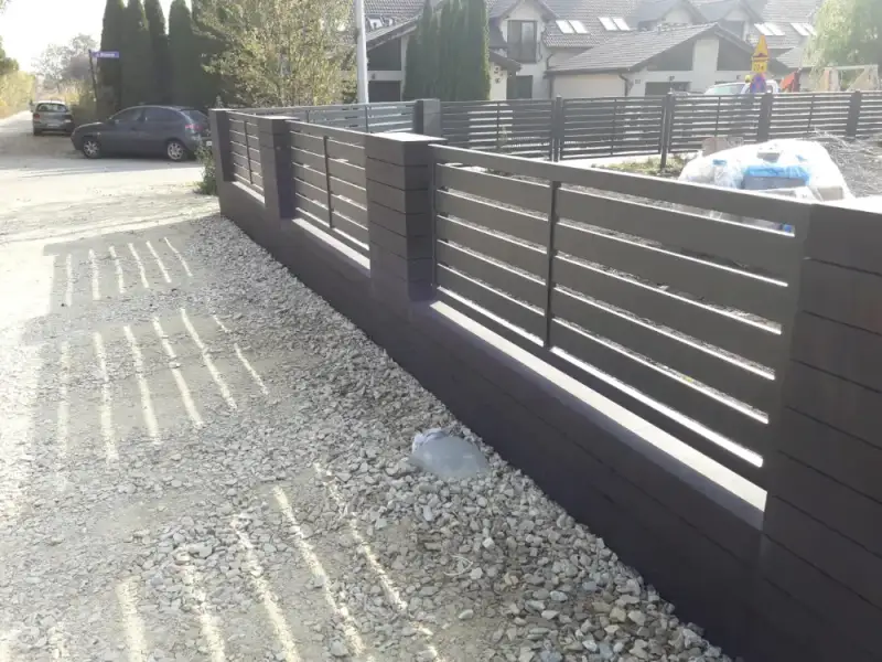 Ogrodzenie palisadowe wzdłuż podjazdu wysypanego żwirem